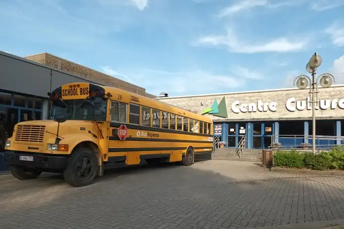 Bus scolaire jaune devant le Centre culturel lors de la visite de Flor’N Scrabble au Scrabblophage en juin 2023.